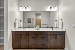 Bathroom featuring baseboards, double vanity, and a closet