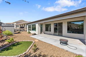 Rear view of property with a patio, stucco siding, an outdoor structure, and a storage unit