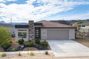 Contemporary house featuring fence, stucco siding, a garage, and concrete driveway