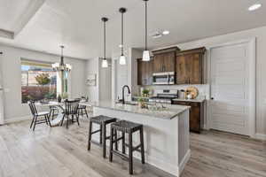 Kitchen featuring stainless steel appliances, light wood-style floors, dark brown cabinetry, recessed lighting, and baseboards