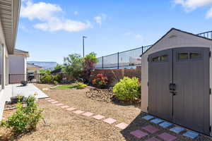 View of shed with a fenced backyard and a mountain view