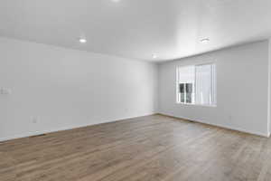 Empty room featuring recessed lighting, baseboards, and wood finished floors