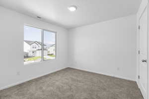 Carpeted empty room with baseboards and visible vents