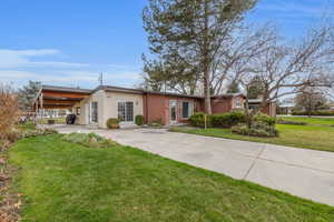 Front yard with mature landscaping and long carport