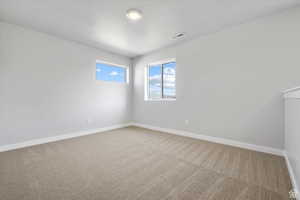 Unfurnished room with baseboards, carpet flooring, and visible vents