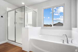 Full bath featuring a stall shower, recessed lighting, wood finished floors, and a bath