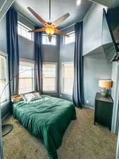 Bedroom with carpet flooring, a textured ceiling, baseboards, a towering ceiling, and ceiling fan