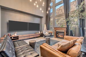 Living room featuring marble finish floor, a fireplace, and a high ceiling