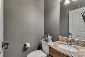 Half bathroom with toilet and vanity