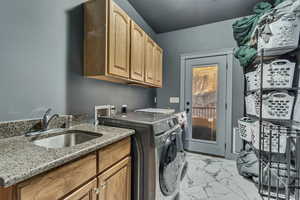 Laundry room with cabinet space, a sink, marble finish floor, and washer and dryer