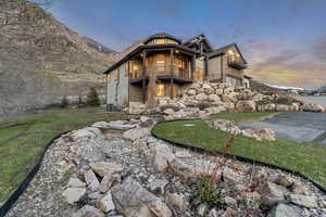 Back of house featuring a balcony and stone siding
