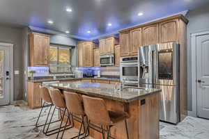 Kitchen featuring marble finish floor, a sink, stainless steel appliances, and decorative backsplash