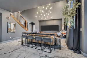 Interior space featuring marble finish floor, visible vents, arched walkways, and stairway