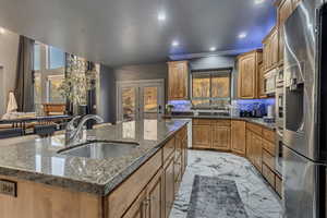 Kitchen featuring marble finish floor, a kitchen island with sink, recessed lighting, appliances with stainless steel finishes, and a sink