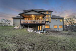 Rear view of property featuring a deck and a yard