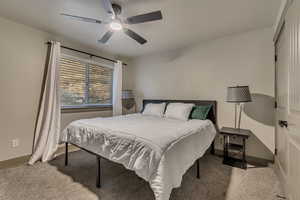 Bedroom with baseboards, carpet flooring, and a ceiling fan