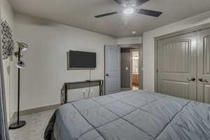 Bedroom with a closet, carpet flooring, baseboards, and a ceiling fan