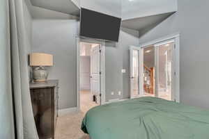 Bedroom featuring light carpet and baseboards