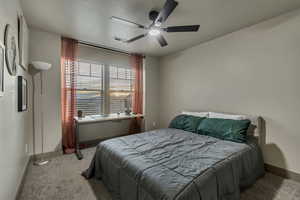 Carpeted bedroom featuring baseboards, ceiling fan, and visible vents