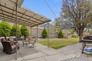 View of patio featuring a fenced backyard, an outdoor structure, and a storage shed