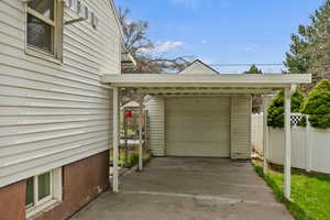 Detached garage with concrete driveway and fence