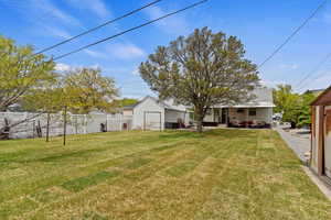 View of yard with outdoor lounge area, a patio area, an outbuilding, and fence