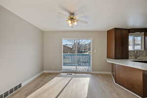 Kitchen featuring visible vents, light wood-style floors, ceiling fan, and a sink