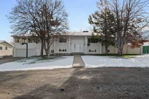 Raised ranch featuring a garage and concrete driveway