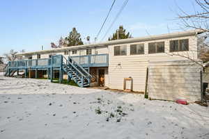 Back of house featuring stairs and a wooden deck