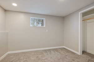 Unfurnished bedroom with carpet flooring, a closet, and baseboards
