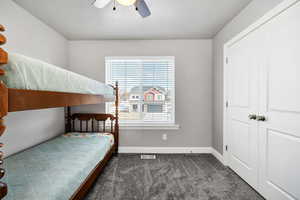 Bedroom featuring carpet, baseboards, visible vents, a ceiling fan, and a closet