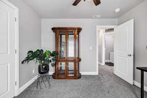 Interior space with carpet floors, baseboards, visible vents, and ceiling fan