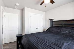 Carpeted bedroom featuring a closet and a ceiling fan