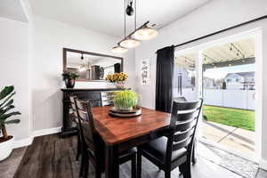 Dining area with visible vents, baseboards, and dark wood finished floors