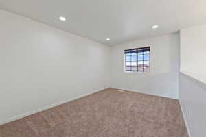 Unfurnished room featuring recessed lighting, baseboards, and carpet