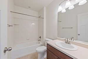 Full bath featuring vanity, shower / tub combination, tile patterned floors, and toilet