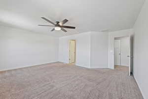 Empty room featuring a ceiling fan, baseboards, visible vents, and light carpet