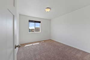 Carpeted spare room with baseboards