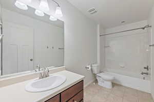 Bathroom with shower / bath combination, tile patterned flooring, vanity, baseboards, and toilet