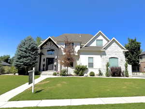 View of front of property featuring stone siding and a front lawn