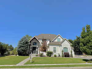 View of front of house featuring stone siding and a front yard