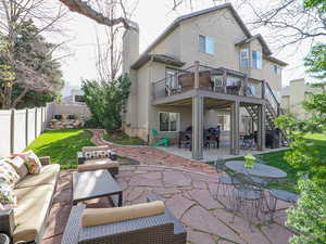 Rear view of house featuring a patio area, a chimney, a fenced backyard, an outdoor living space, and stucco siding