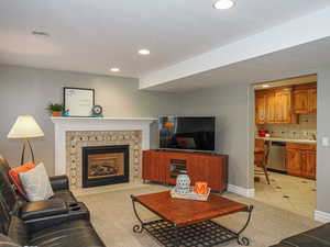Living room featuring baseboards, a fireplace, recessed lighting, and light tile patterned floors