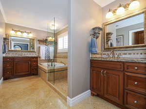 Full bathroom with tile patterned flooring, ornamental molding, a sink, two vanities, and a bath