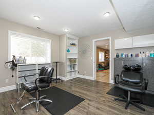 Home office featuring dark wood finished floors, baseboards, visible vents, and a textured ceiling
