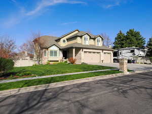 View of front of property featuring stucco siding, driveway, a front yard, a garage, and fence