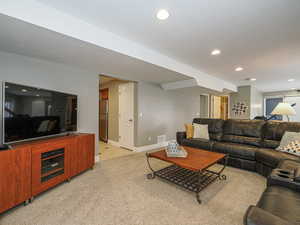 Living room with visible vents, baseboards, recessed lighting, light tile patterned floors, and light colored carpet