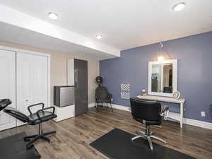 Home office featuring a textured ceiling, baseboards, and wood finished floors