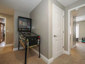 Hallway with baseboards and carpet floors