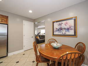 Dining space with light tile patterned flooring, baseboards, and recessed lighting